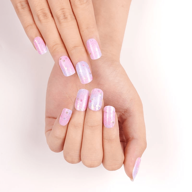 Pink and blue gradient glitter nail wraps on hands showing cosmic ombre nail art