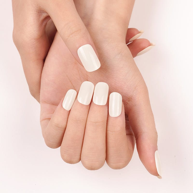 Pearlescent white nail wraps on cupped hands displaying minimalist oval nail art design