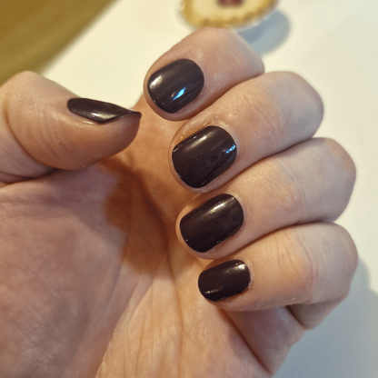 Deep berry purple nail wraps on hand showing glossy finish manicure