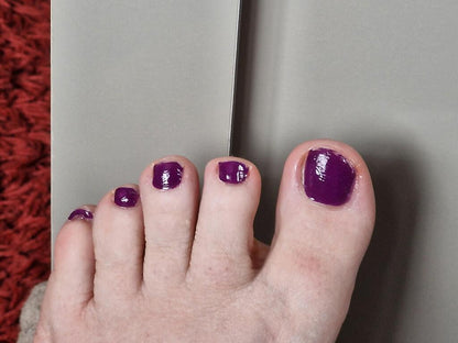 Purple glossy pedicure wraps applied to foot showing elegant mulberry nail art