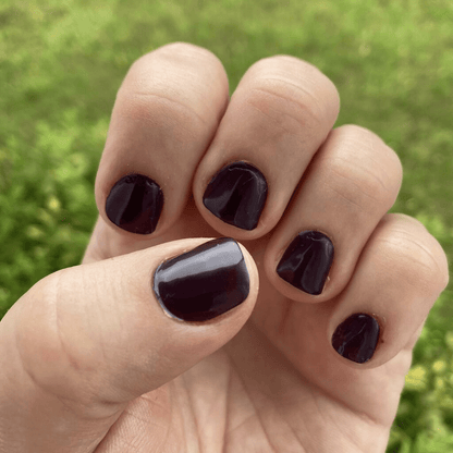 Dark purple mulberry nail wraps worn outdoors showing rich glossy finish