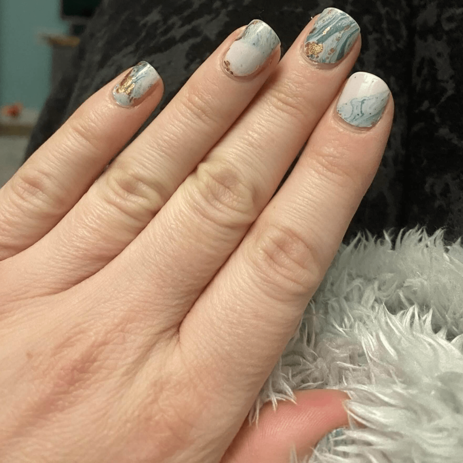 Blue marble nail wraps on fingers showing watercolour stone effect manicure design
