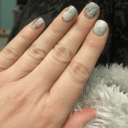 Blue marble nail wraps on fingers showing watercolour stone effect manicure design