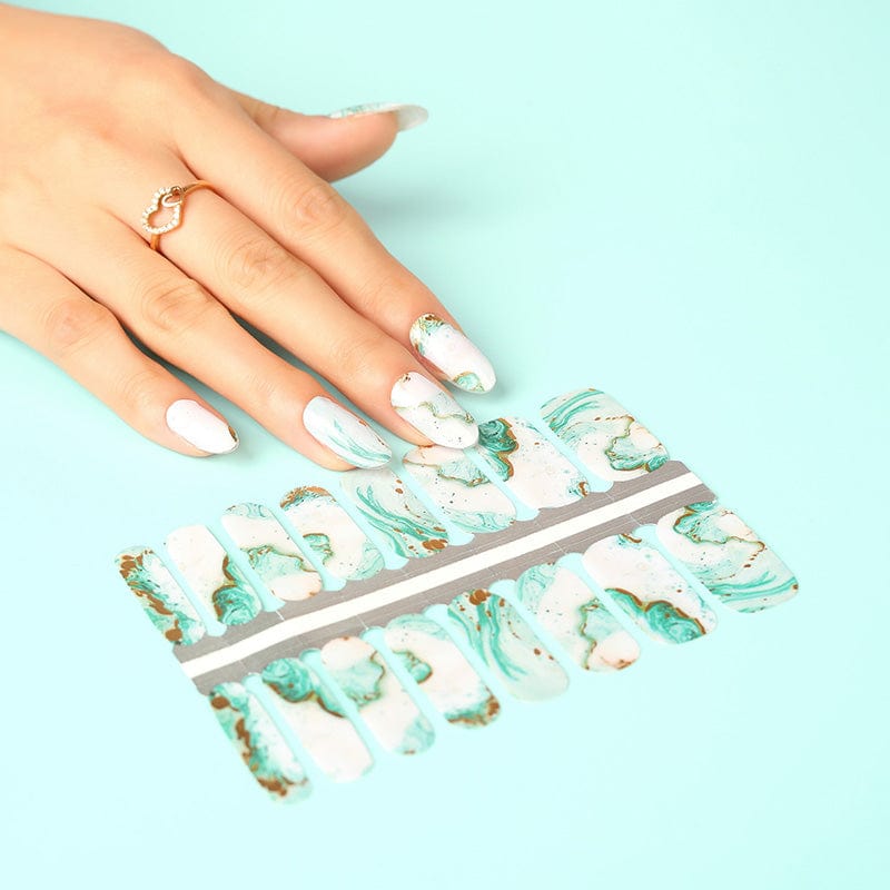 Hand applying blue marble nail wraps with watercolour stone effect non-UV manicure design
