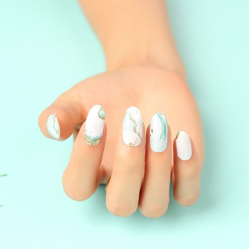 Hand displaying blue marble nail wraps with watercolour stone effect non-UV manicure art