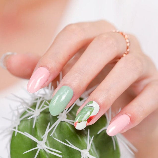 Manicured hand with botanical nail art featuring sage green and peachy pink palm leaf designs