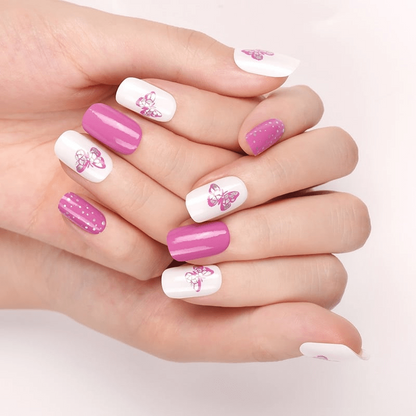 Pink butterfly nail wraps on hand showing mixed polka dot and solid manicure design