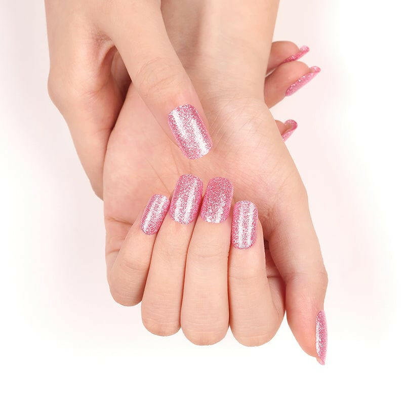 Hands showcasing pink sparkly nail wraps for at-home nail art