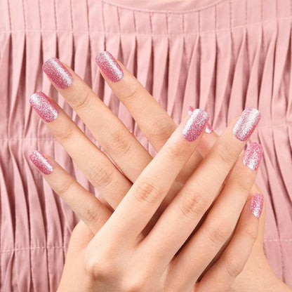 Two hands displaying pink glitter nail wraps for DIY manicure