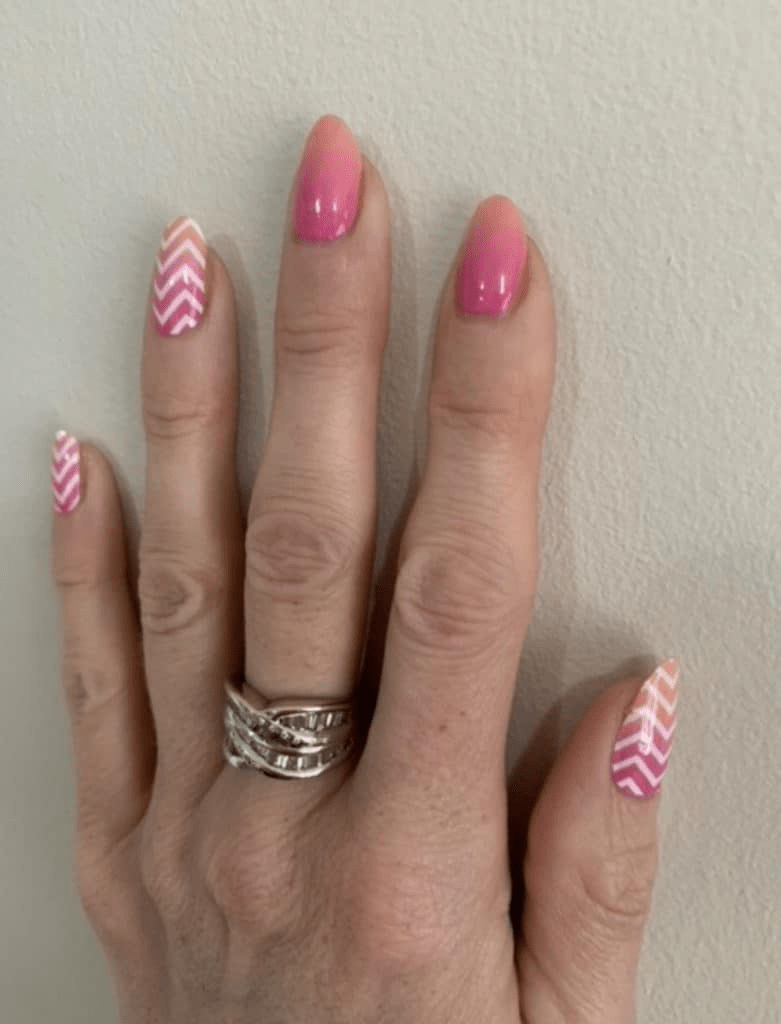 Peach to pink gradient gel nail wraps with geometric chevron design on fingernails