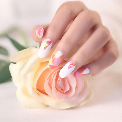 Hand with geometric nail art wraps in pink coral orange touching cream rose flower