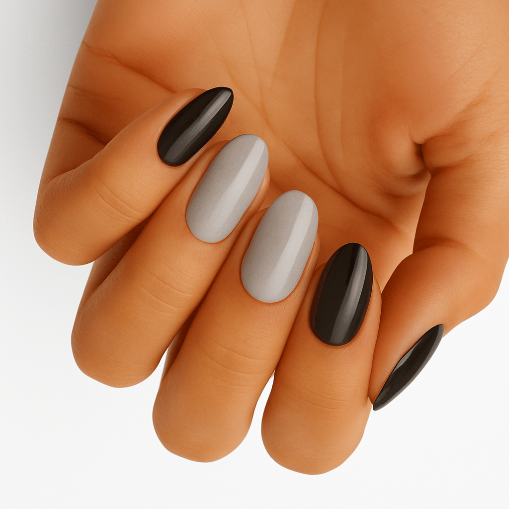 Black and grey glossy oval nail wraps on hand showing monochrome manicure design