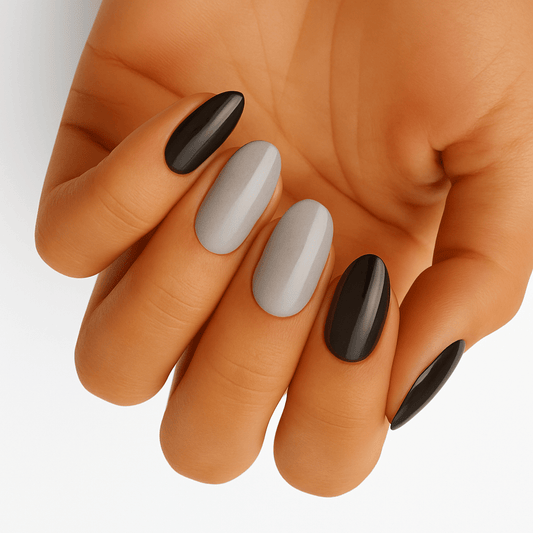 Black and grey glossy oval nail wraps on hand showing monochrome manicure design