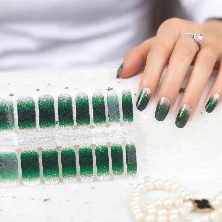 Green ombre nail wraps sheet with hand showing applied gradient glitter manicure