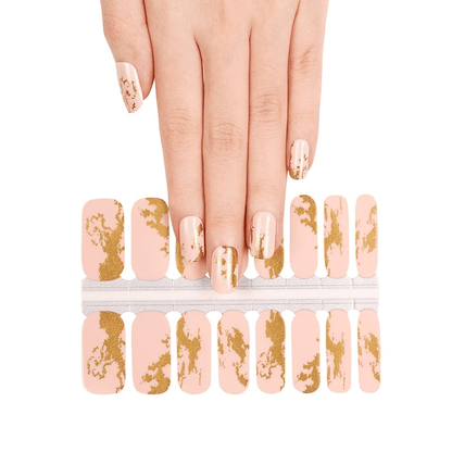 Gold foil nail wraps showing nude base with metallic accents and hand application