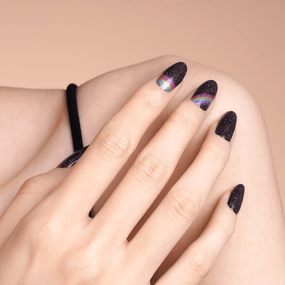 Black glitter nail wraps with rainbow holographic design on hand manicure