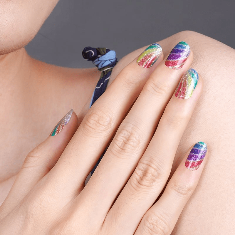 Hand wearing vibrant rainbow swirl non-UV nail wraps with multicoloured psychedelic swirl design