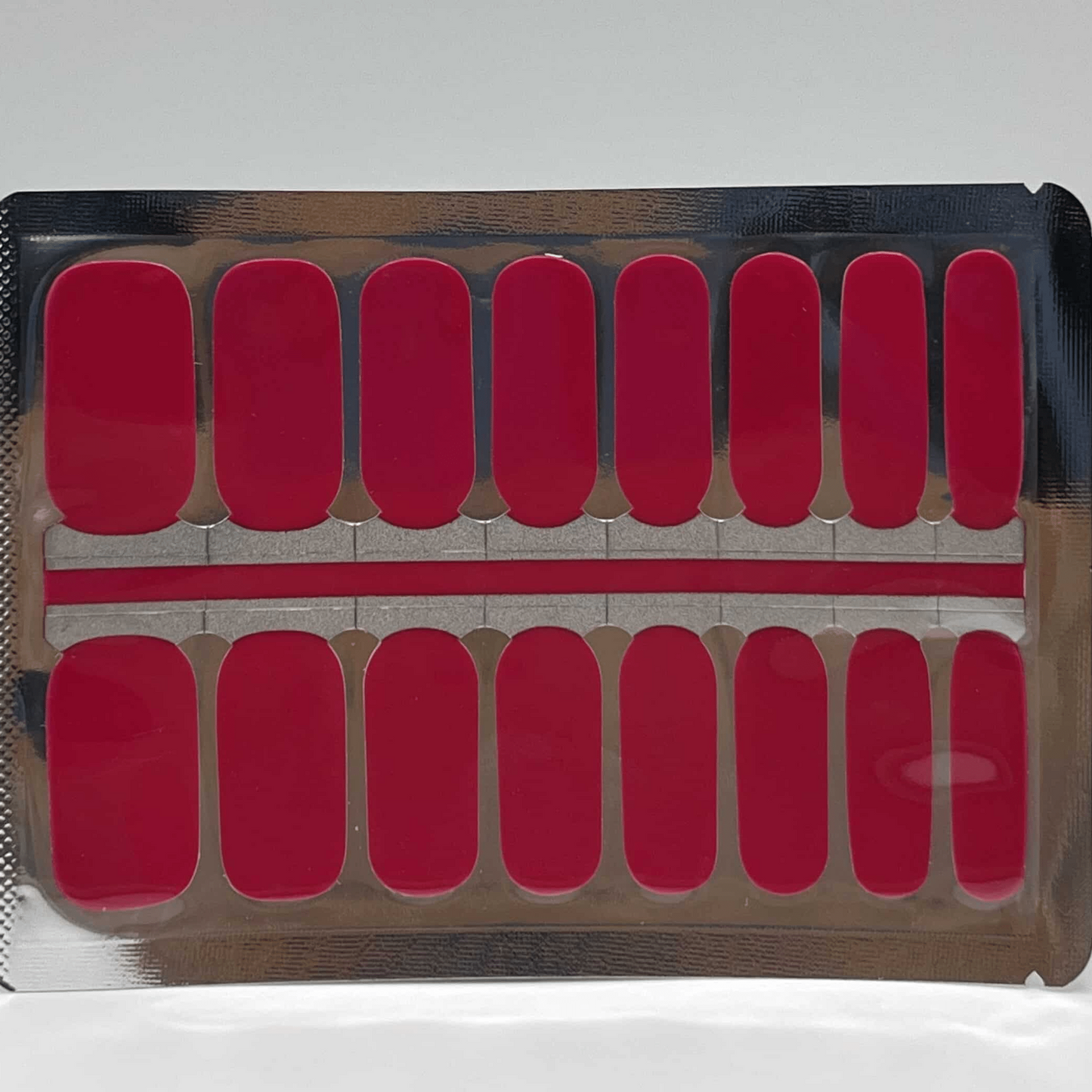 Sheet of raspberry pink non-UV nail wraps showing multiple sizes for perfect fit