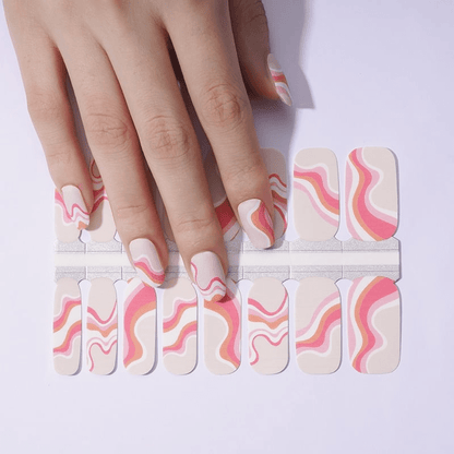 Pink coral swirl nail wraps on hand with cream and peach marble pattern for at-home manicure