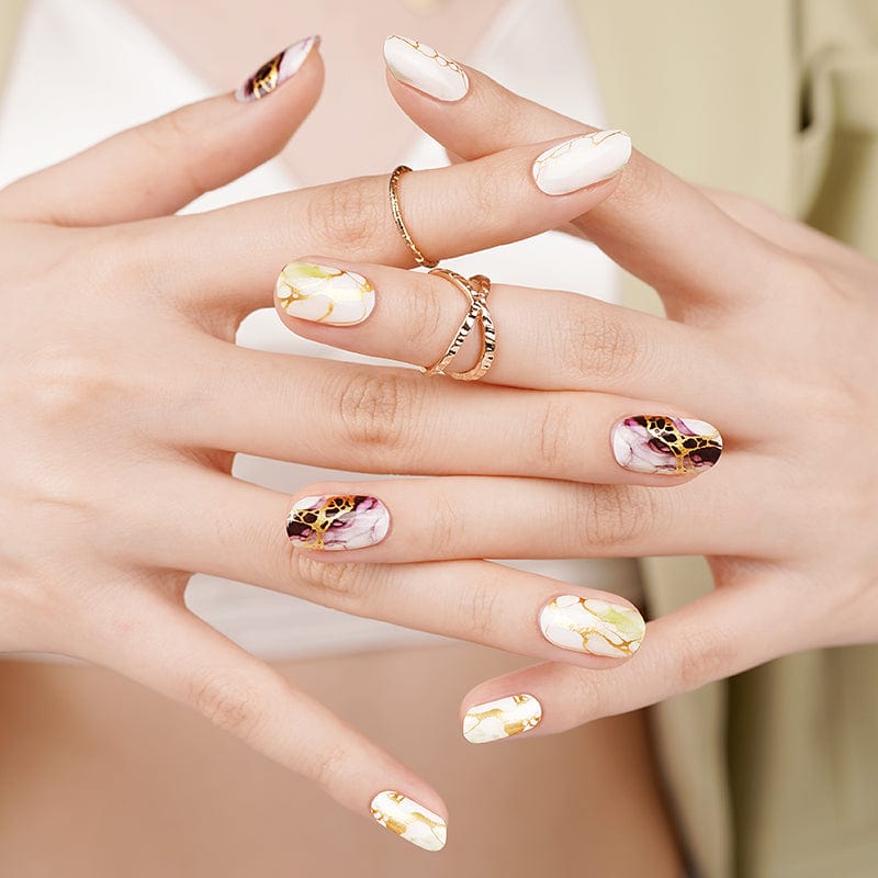 Hands wearing sophisticated marble nail wraps in neutral sage and mauve tones for elegant manicure
