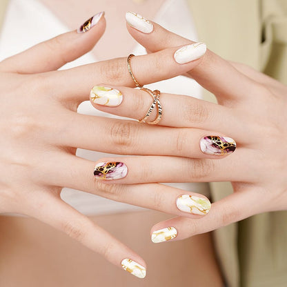 Hands wearing sophisticated marble nail wraps in neutral sage and mauve tones for elegant manicure