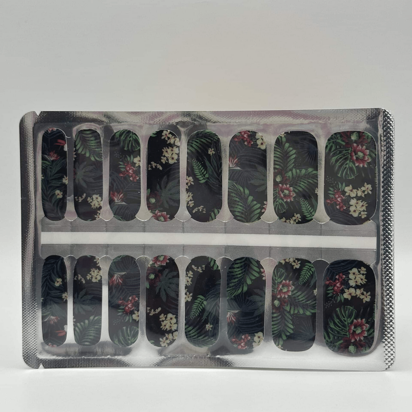 Sheet of jungle print nail wraps with tropical leaves and flowers in packaging