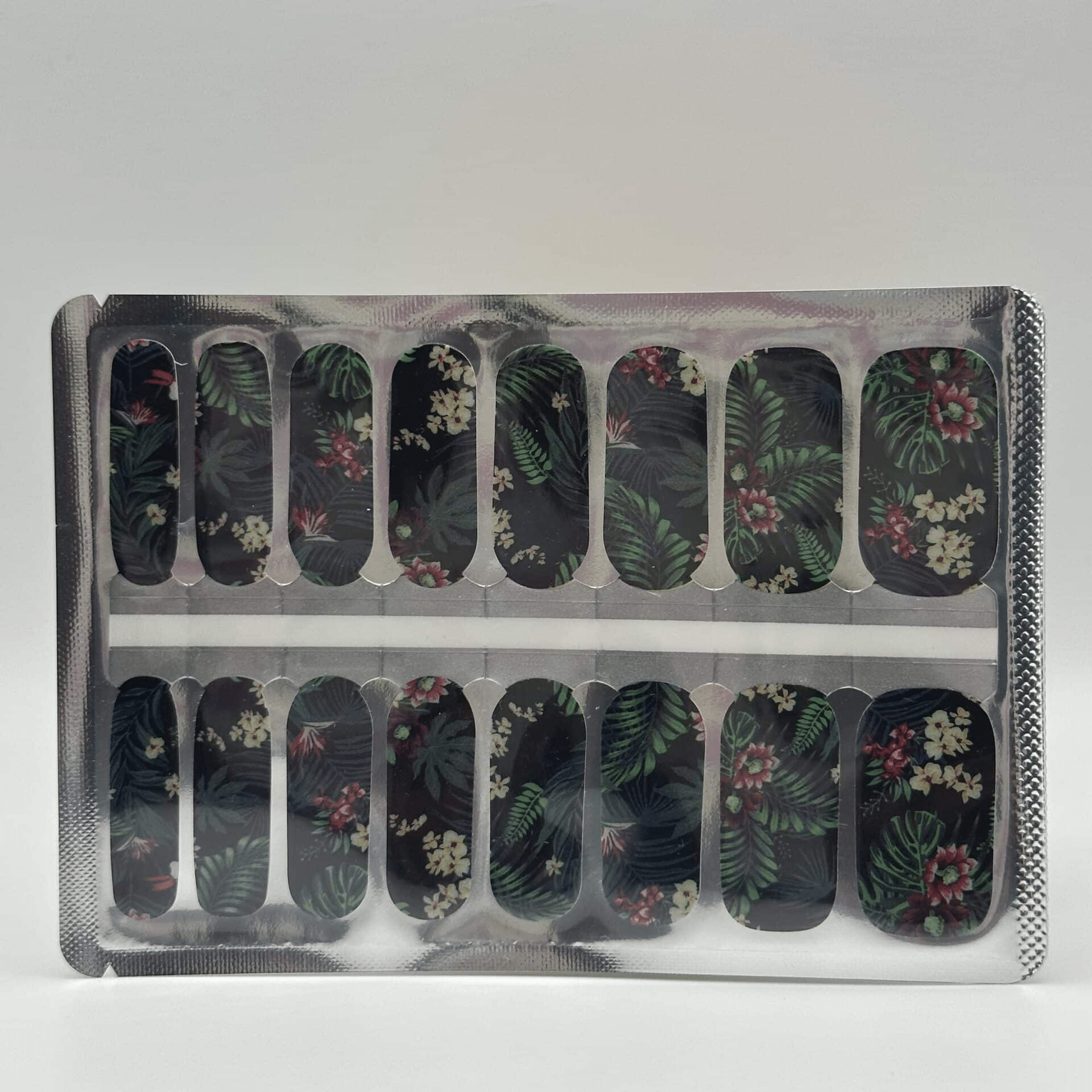 Sheet of jungle print nail wraps with tropical leaves and flowers in packaging