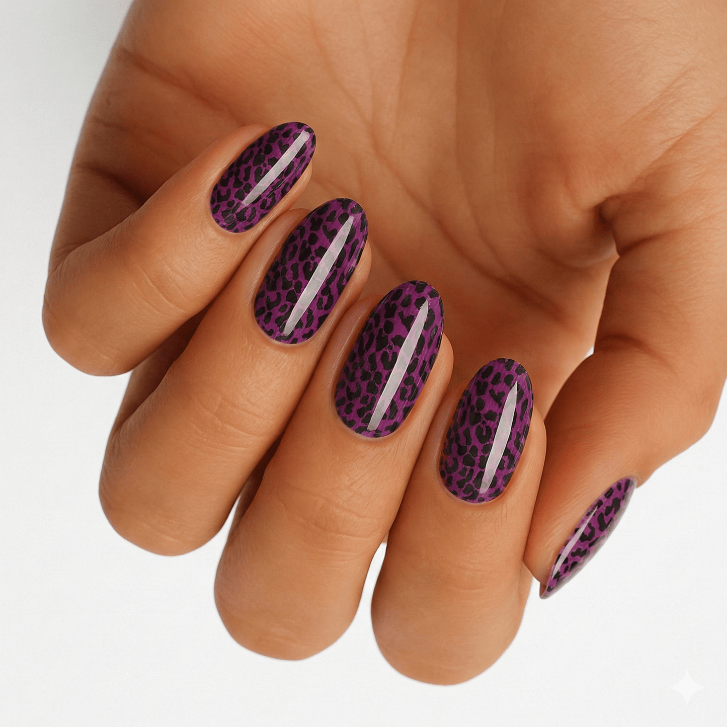 Purple leopard print nail wraps on hand showing metallic animal print manicure design