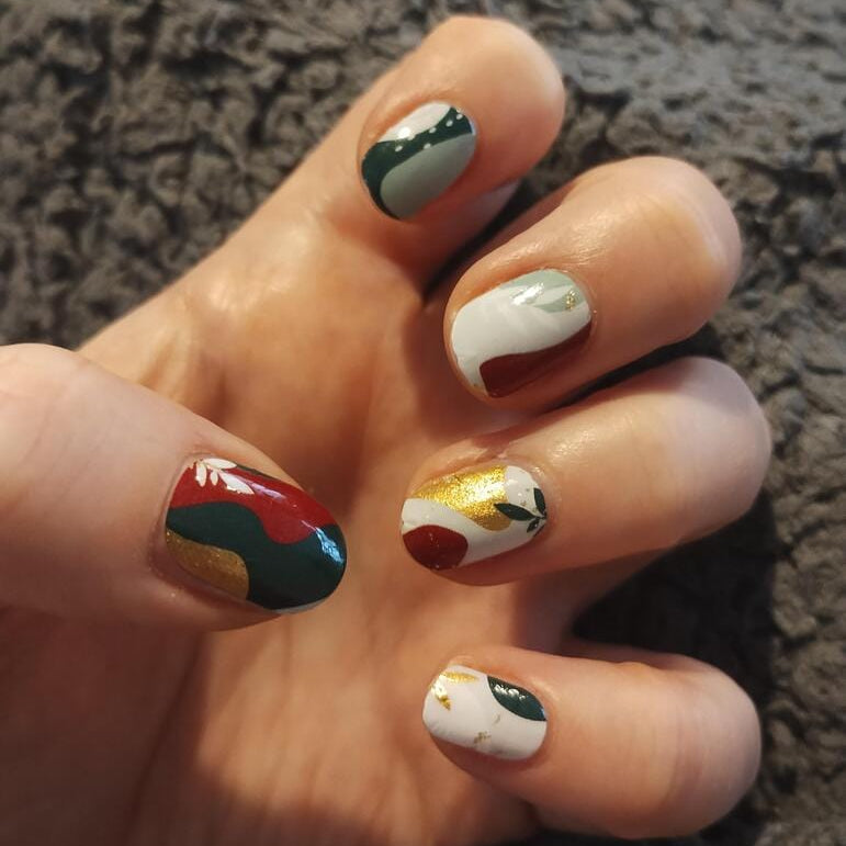Abstract sage green and terracotta nail art wraps applied on hand showing autumn colours