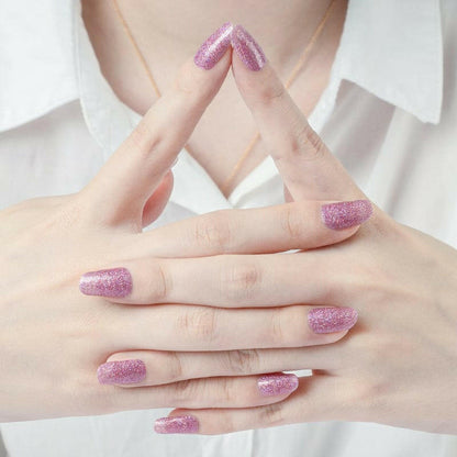 Pink glitter nail wraps on hands showing shimmer mauve manicure for at-home nail art