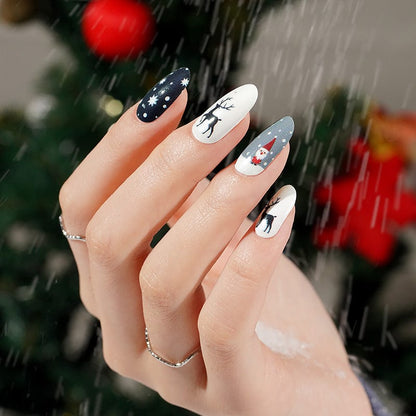 Festive nail art on hand showing Christmas nail wraps with snowflakes, reindeer and holiday designs