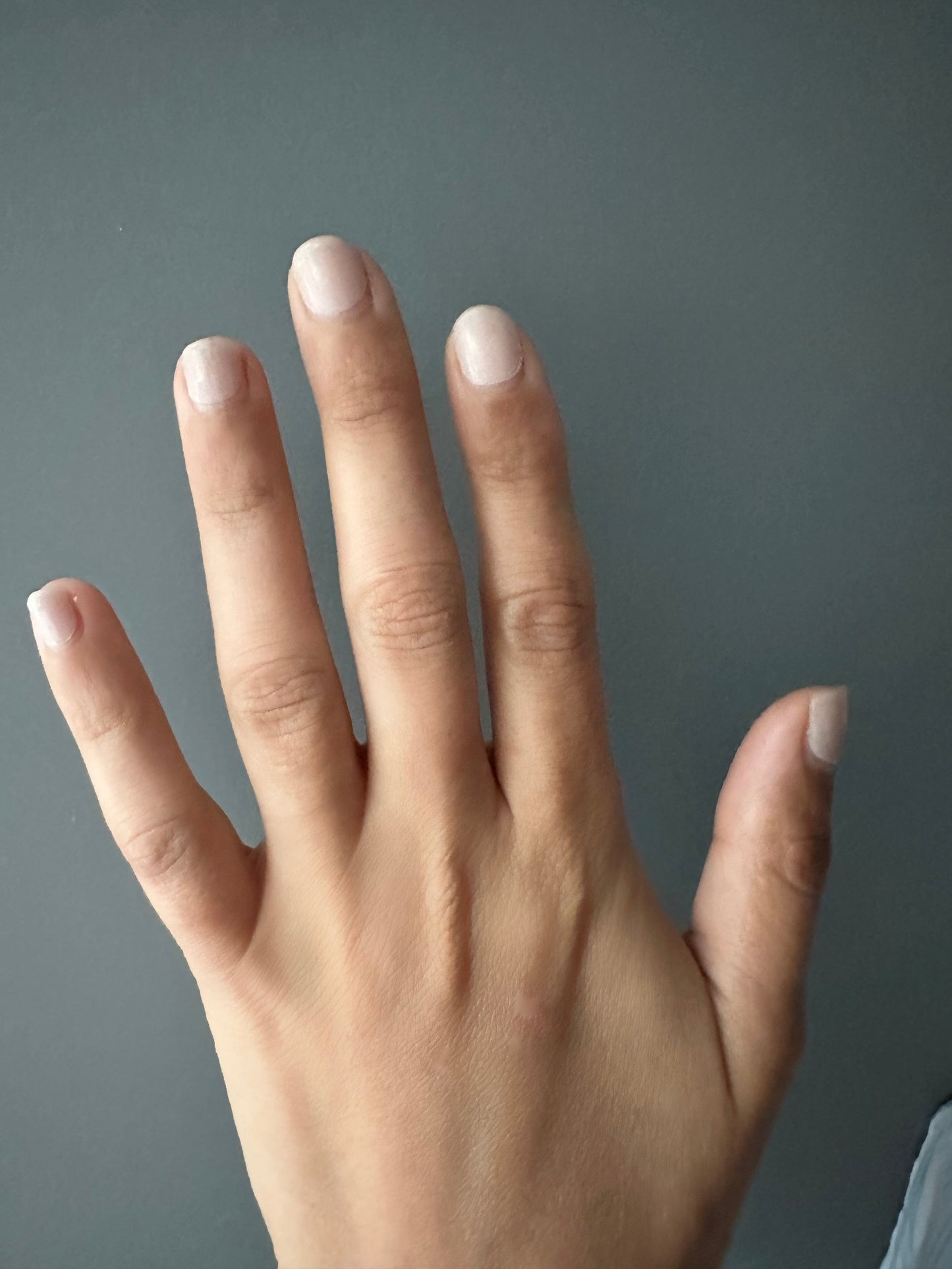 Neutral beige nail wraps on open hand showing clean minimalist at-home manicure