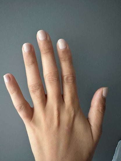 Neutral beige nail wraps on open hand showing clean minimalist at-home manicure