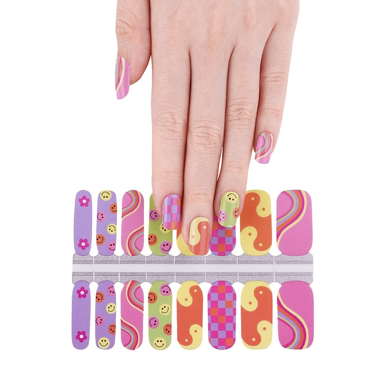 Hand applying colourful non-UV nail wraps with smiley faces, rainbows and retro patterns