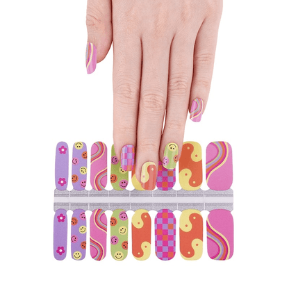 Hand applying colourful non-UV nail wraps with smiley faces, rainbows and retro patterns