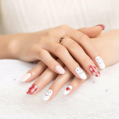 White Christmas nail wraps featuring cute snowman characters with red hearts on manicured hands