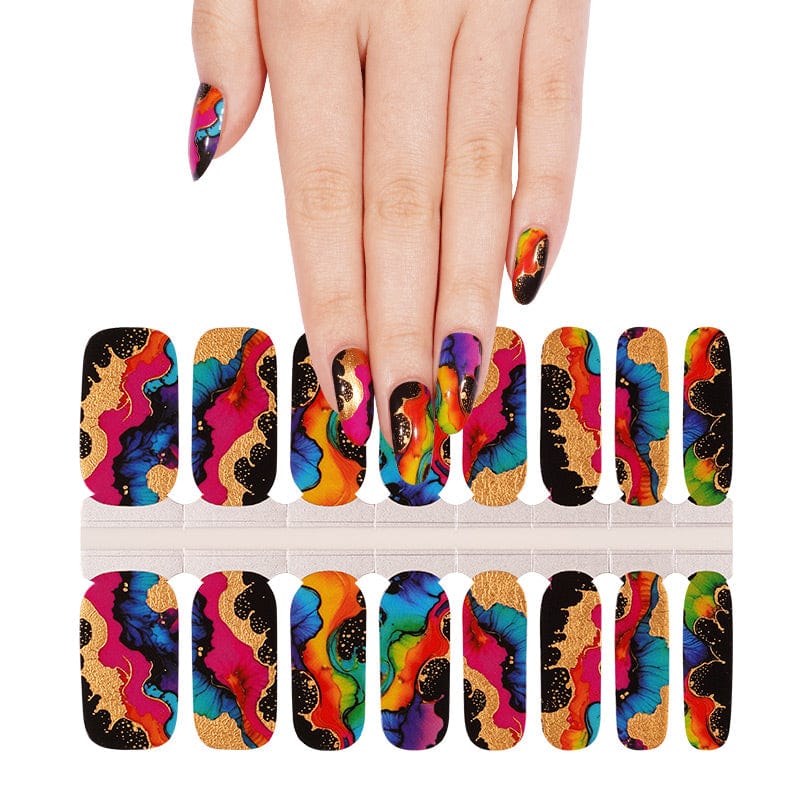 Hand wearing colourful abstract nail wraps with gold accents next to wrap sheet