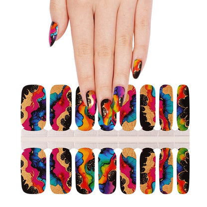 Hand wearing colourful abstract nail wraps with gold accents next to wrap sheet