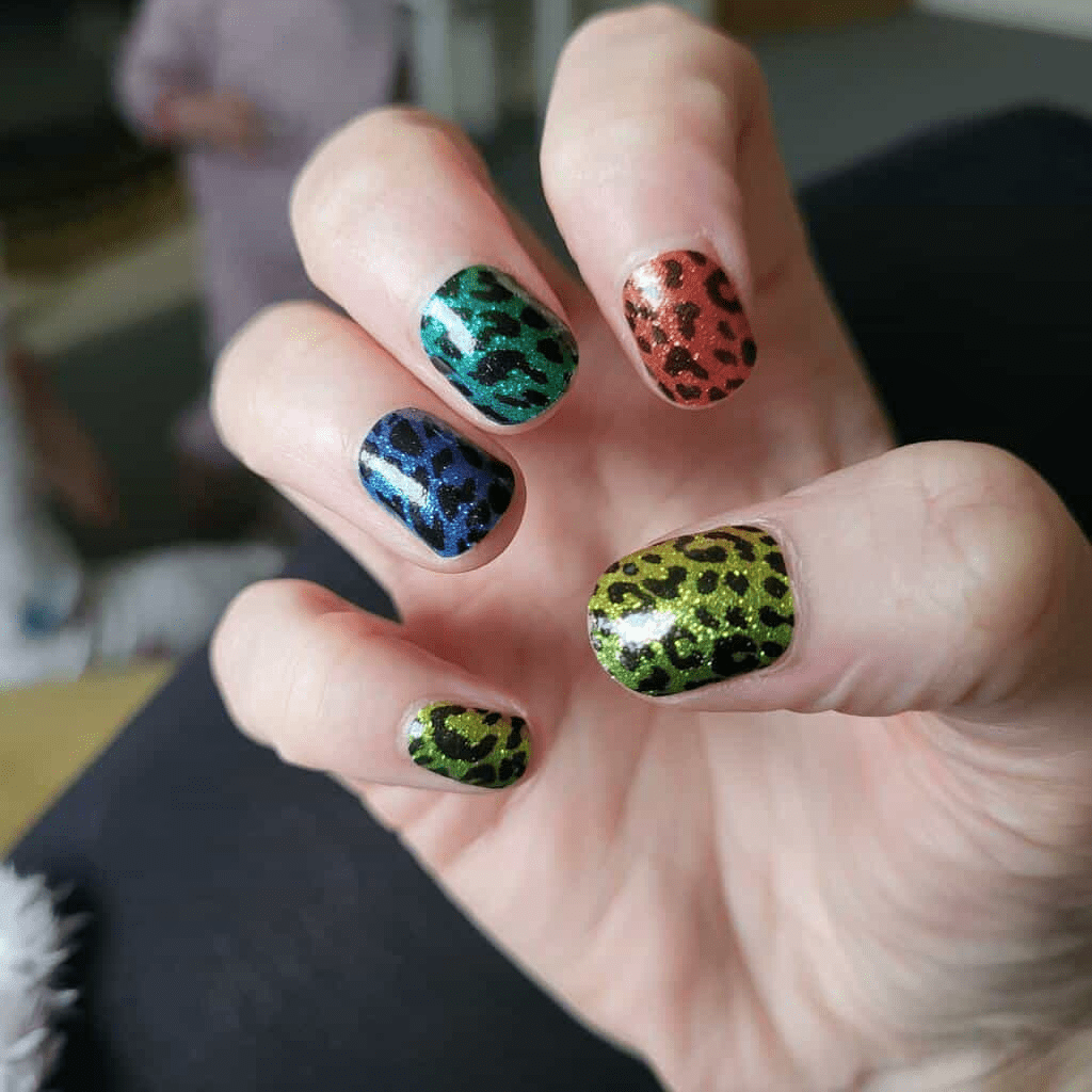 Rainbow leopard print nail wraps on hand showing multicoloured animal print manicure design