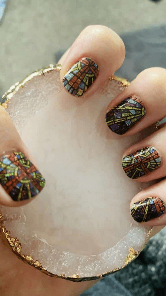 Multicoloured stained glass nail wraps applied on short nails showing intricate mosaic design