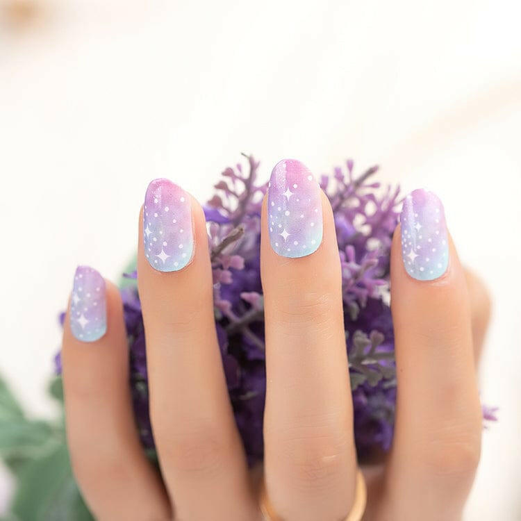 Hands displaying pink blue gradient nail wraps with polka dot pattern for nail art