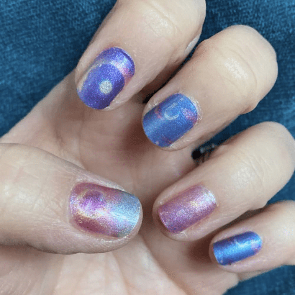Purple blue ombre gel nail wraps with shimmer finish on hand celestial manicure