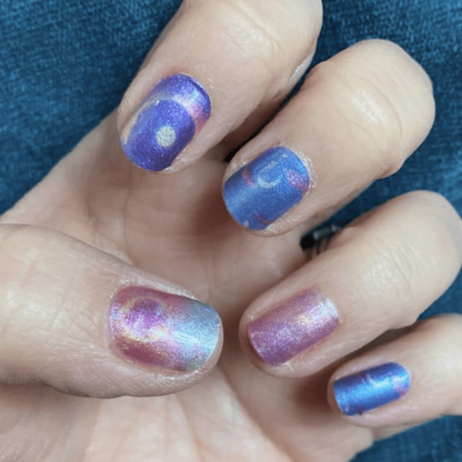 Purple blue ombre gel nail wraps with shimmer finish on hand celestial manicure