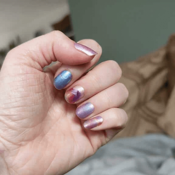 Cosmic gradient nail wraps on hand showing blue purple pink starry night design non-UV