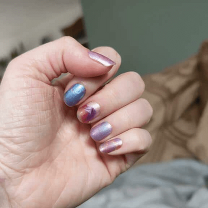 Cosmic gradient nail wraps on hand showing blue purple pink starry night design non-UV