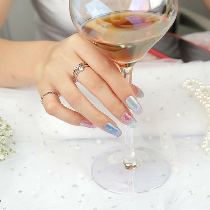 Starry night ombre nail wraps on manicured hand holding wine glass blue purple gradient design