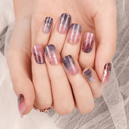 Manicured hands wearing pink blue marble effect nail wraps with watercolour stone pattern