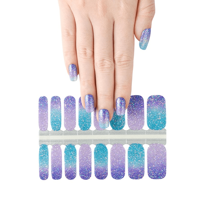 Purple turquoise gradient glitter nail wraps displayed on hand with cosmic ombre design