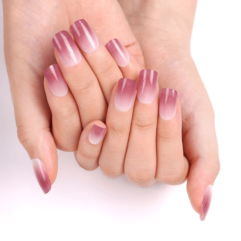 Hands displaying pink ombre gel nail wraps with gradient manicure finish