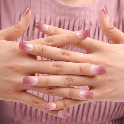Woman's hands showing dusty rose ombre nail art against pink pleated fabric